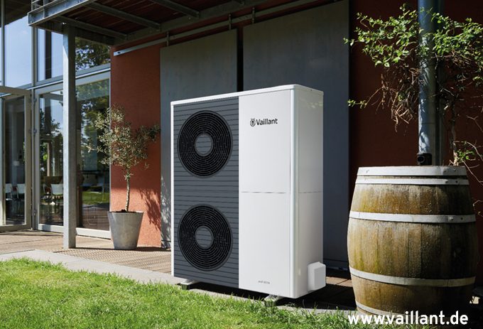Vaillant aroTherm VWL 105 Wärmepumpe vor einer Ziegelsteinwand, steht auf einem gepflasterten Boden.